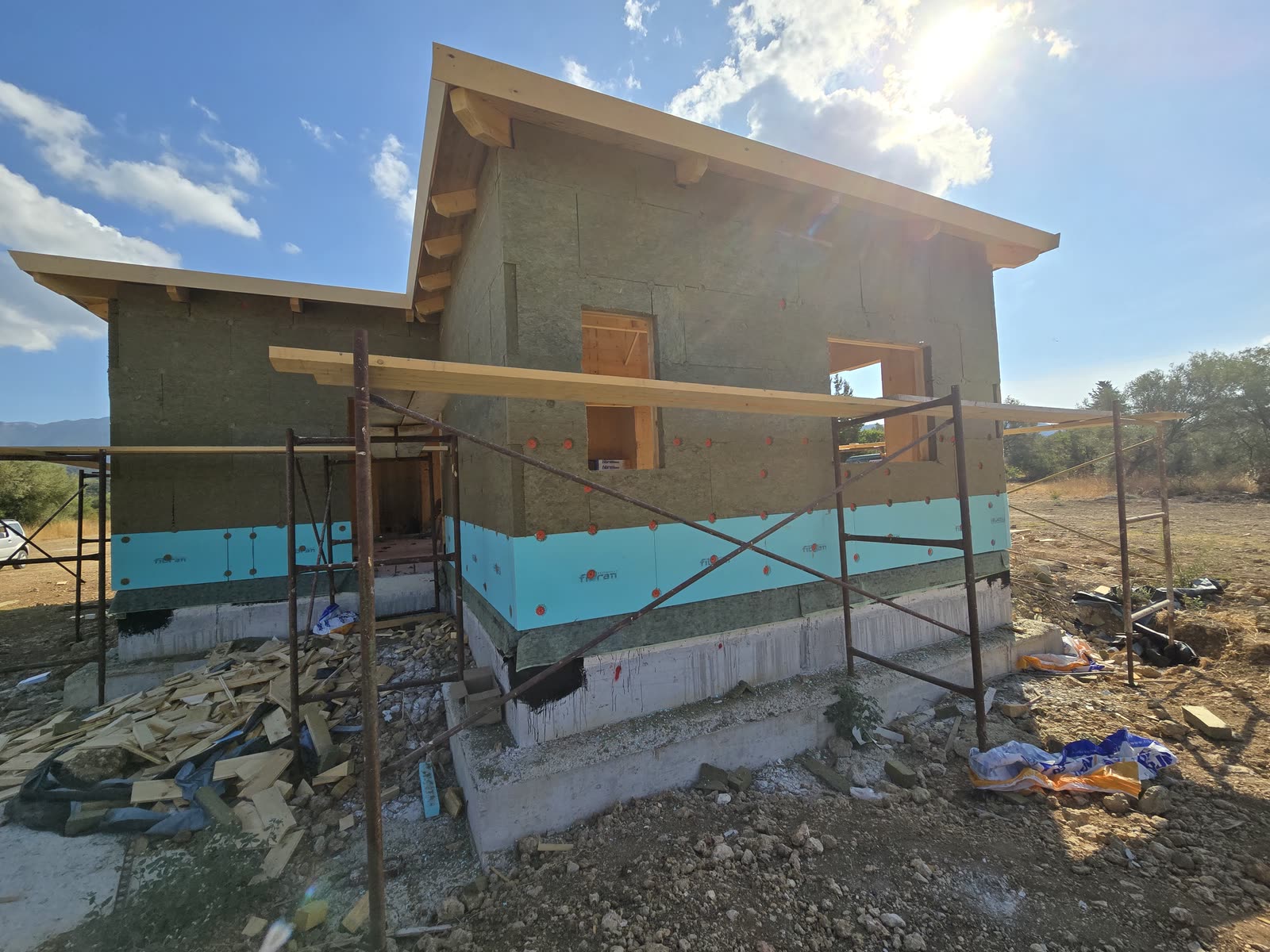 Insulation boards being fixed to the facades of the CLT house in Lefkada